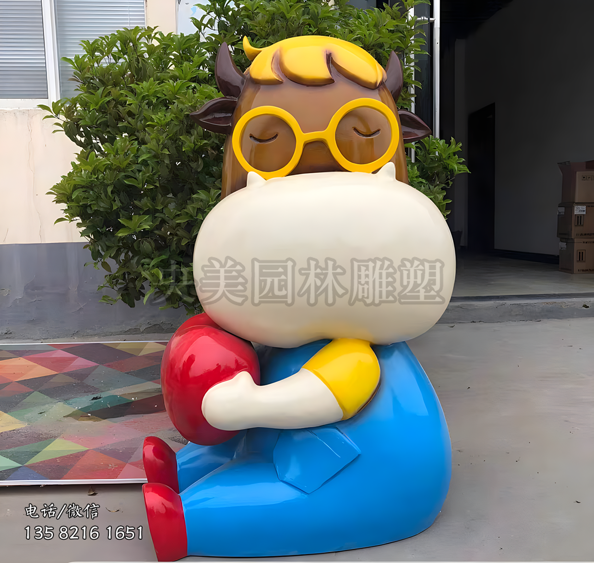 戴眼鏡坐地上的卡通牛雕塑